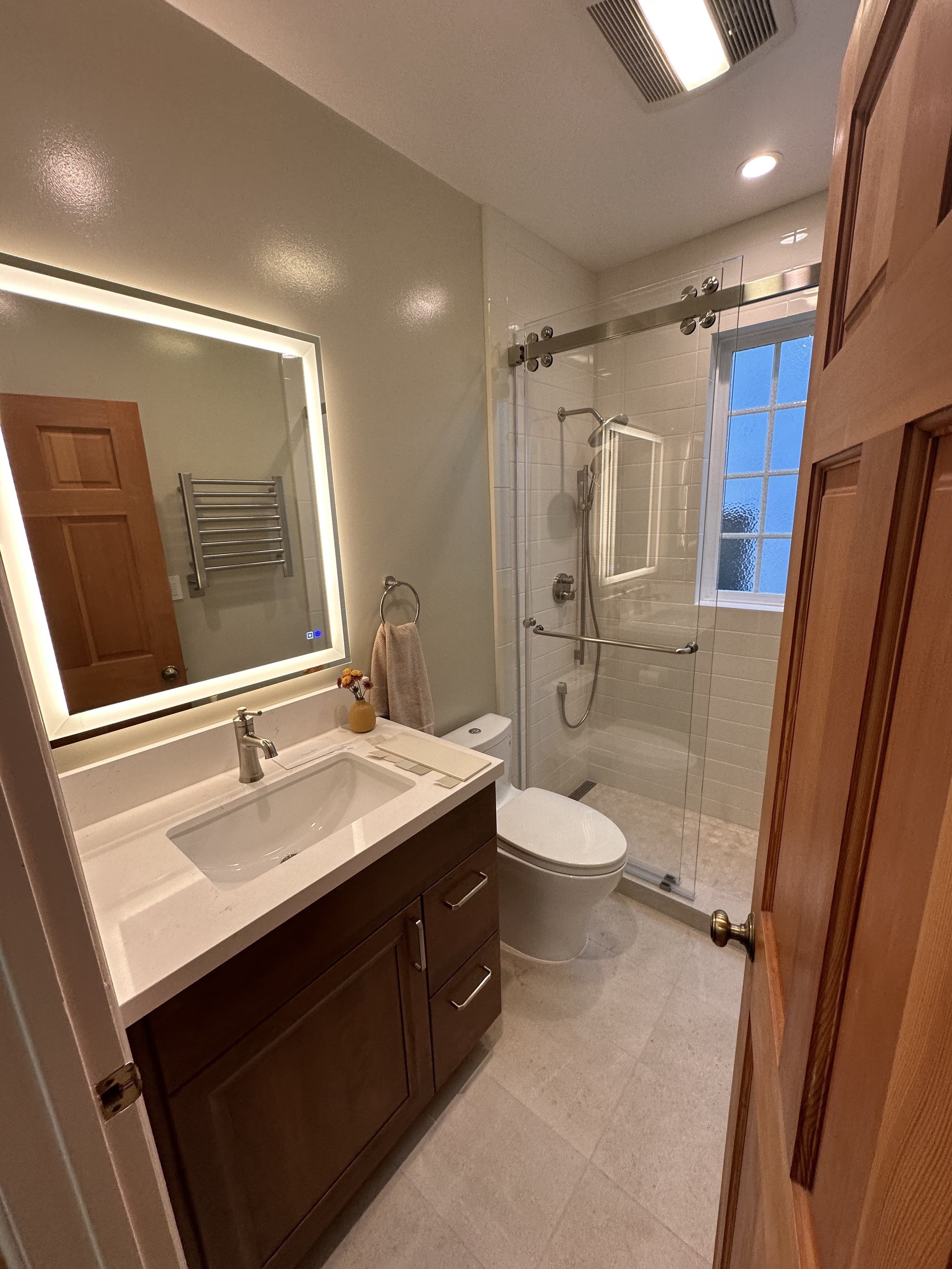 Bathroom renovation with glass shower and smart mirror