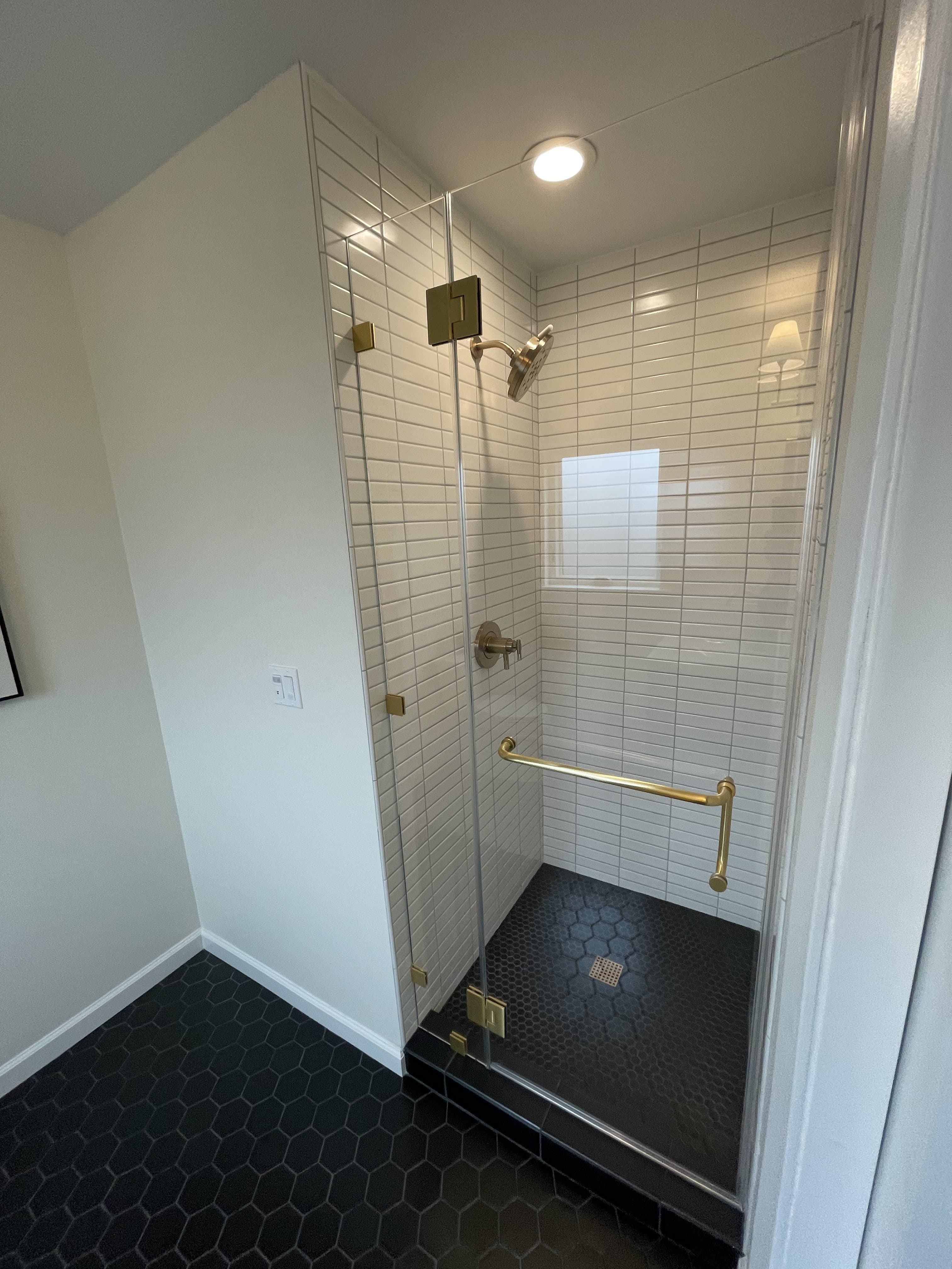 Luxury walk-in shower with white subway tile and gold fixtures